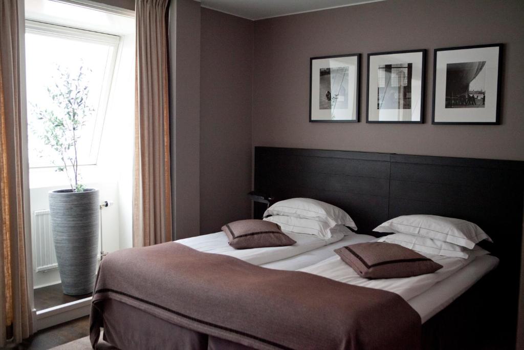 een slaapkamer met een groot bed en een raam bij Hotel Villan in Göteborg