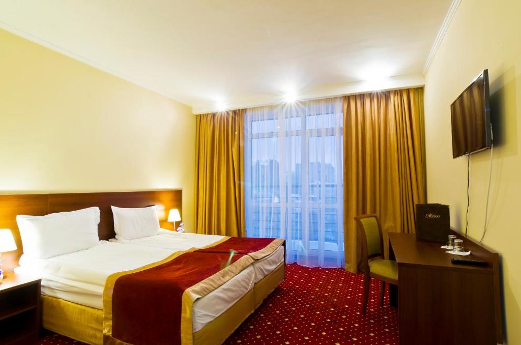 カザンにあるDavidov Hotelのベッドと大きな窓が備わるホテルルームです。