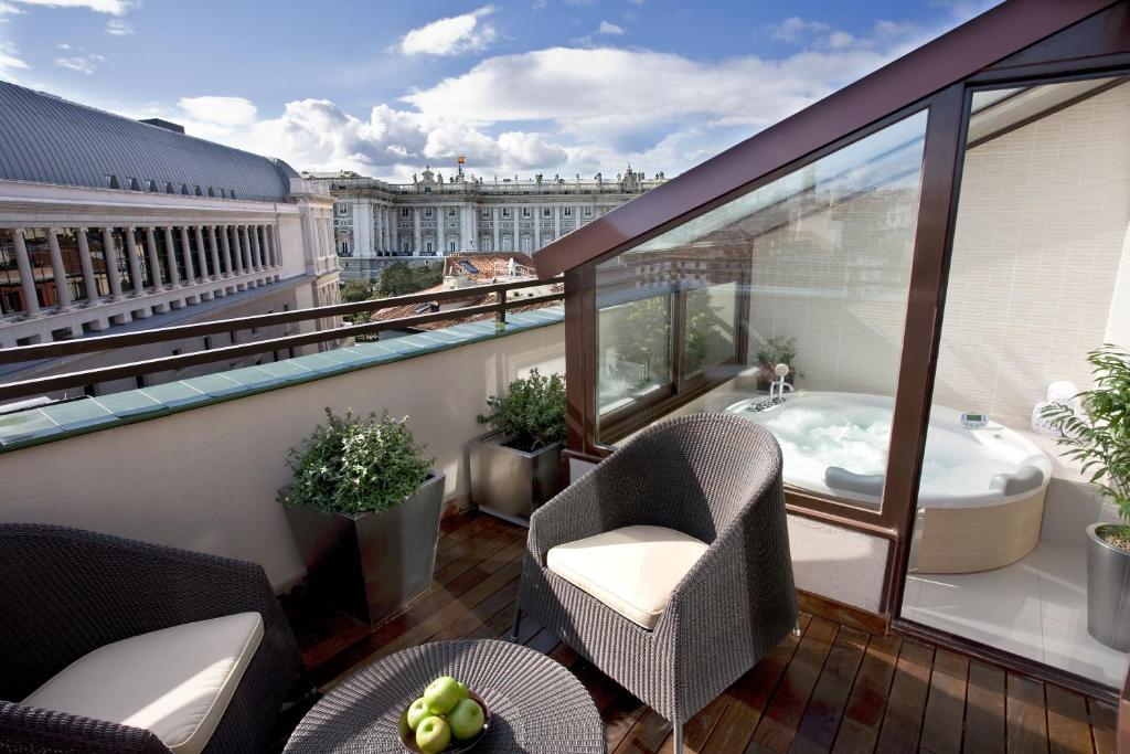 a balcony with a tub and a chair on a building at Hotel Opera in Madrid