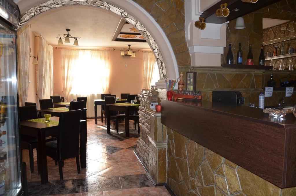 a bar with tables and chairs in a restaurant at Garden Vendégház Makó in Makó