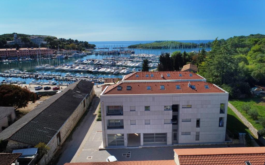 a building with a red roof next to a marina at Romana Serena Sunset in Vrsar