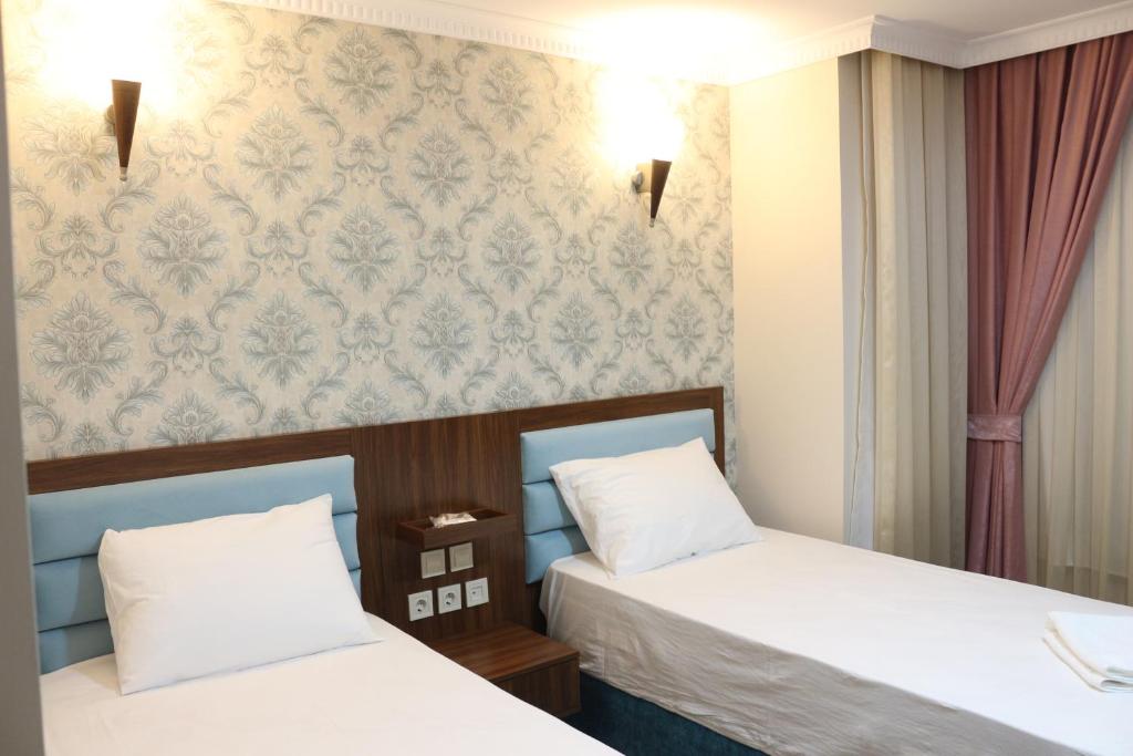 Postel nebo postele na pokoji v ubytování HOTEL ÜMİT YENİKAPI