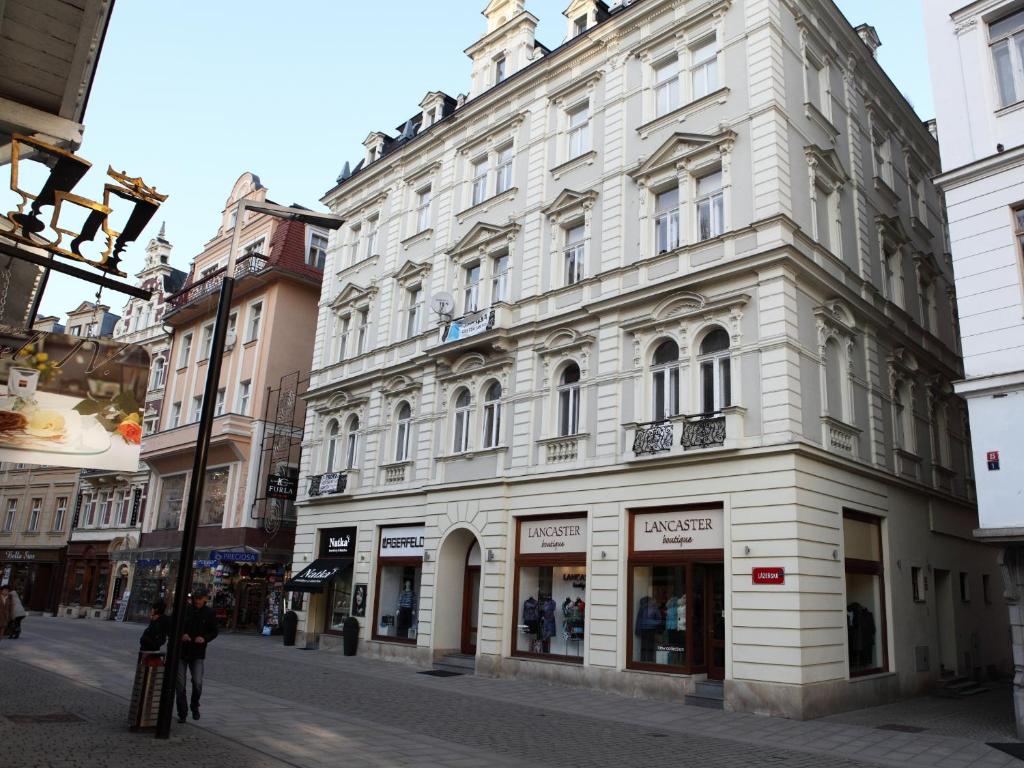 a large white building on a city street at 7k - Apartmány Lázeňská in Karlovy Vary