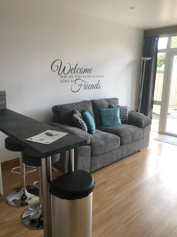 ein Wohnzimmer mit einer Couch und einem Tisch in der Unterkunft Our Wendy House in Holsworthy