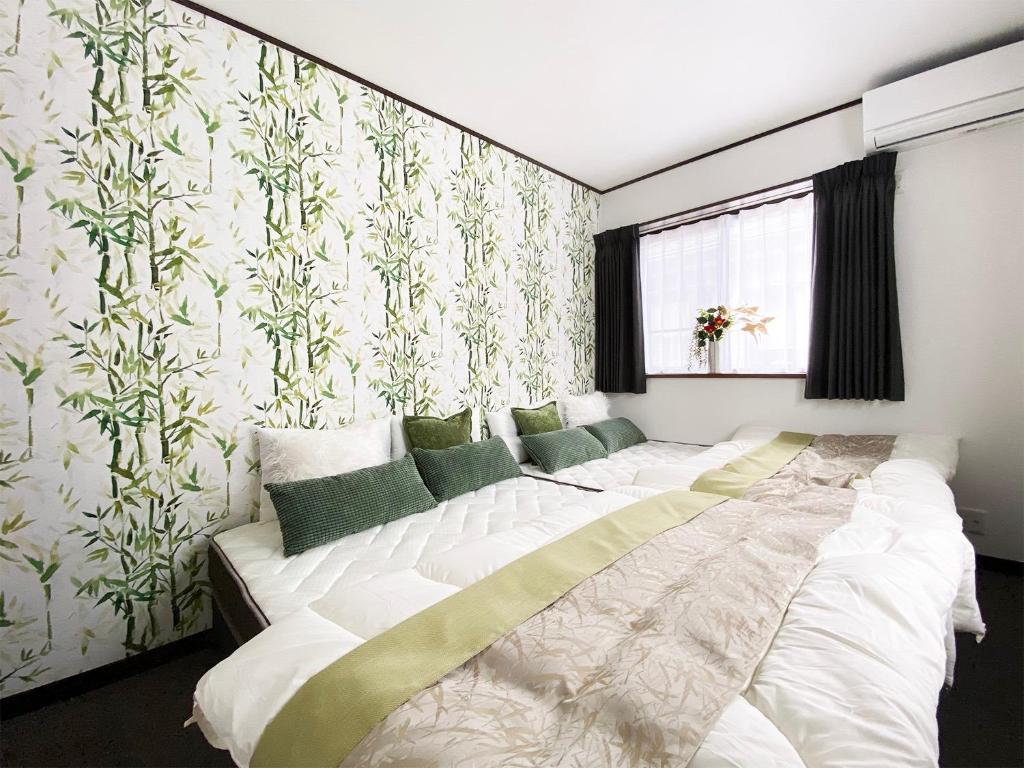 sypialnia z 2 łóżkami i ścianą z tapetą w obiekcie Sky House Fujikawaguchiko - Vacation STAY 98122 w mieście Azagawa