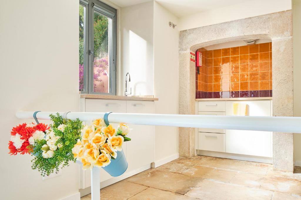 a kitchen with a counter with a vase of flowers at Sintra Bliss A Part in Sintra
