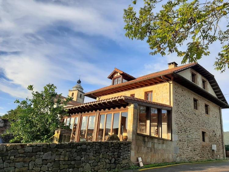 un gran edificio con ventanas de cristal y una torre en Posada El Hidalgo en Valdecilla