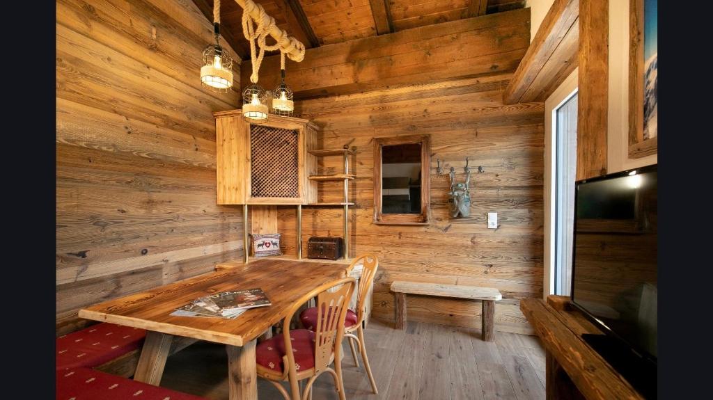 ein hölzernes Esszimmer mit einem Holztisch und Stühlen in der Unterkunft Apartment Wagrainblick in Wagrain