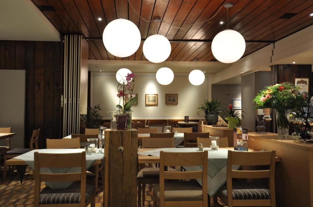 een restaurant met tafels, stoelen en verlichting bij Gasthaus Sonne GbR in Trennfeld