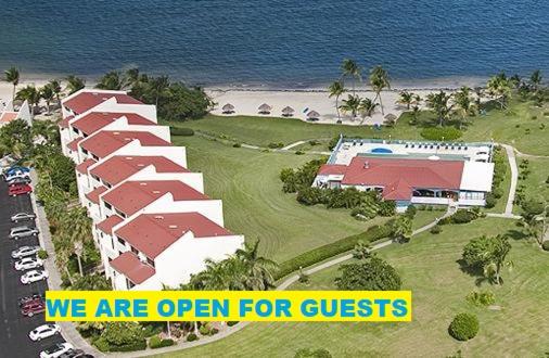 a resort with a sign that says we are open for guests at Club St. Croix Beach and Tennis Resort in Christiansted