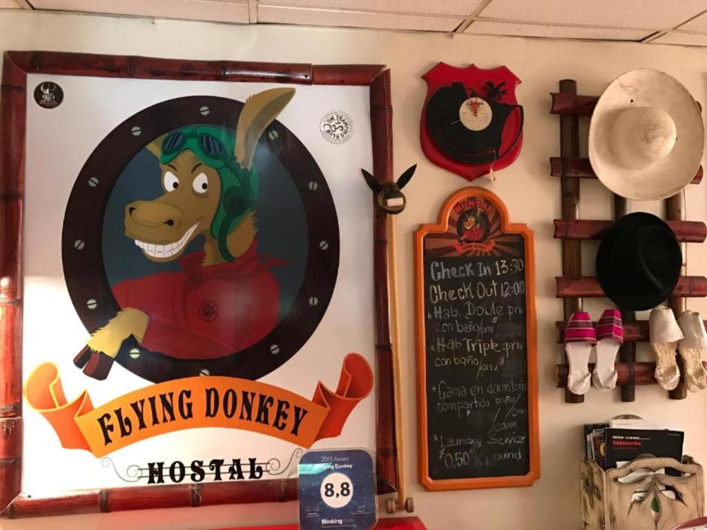 a sign for a flying donkey hanging on a wall at Flying Donkey in Otavalo