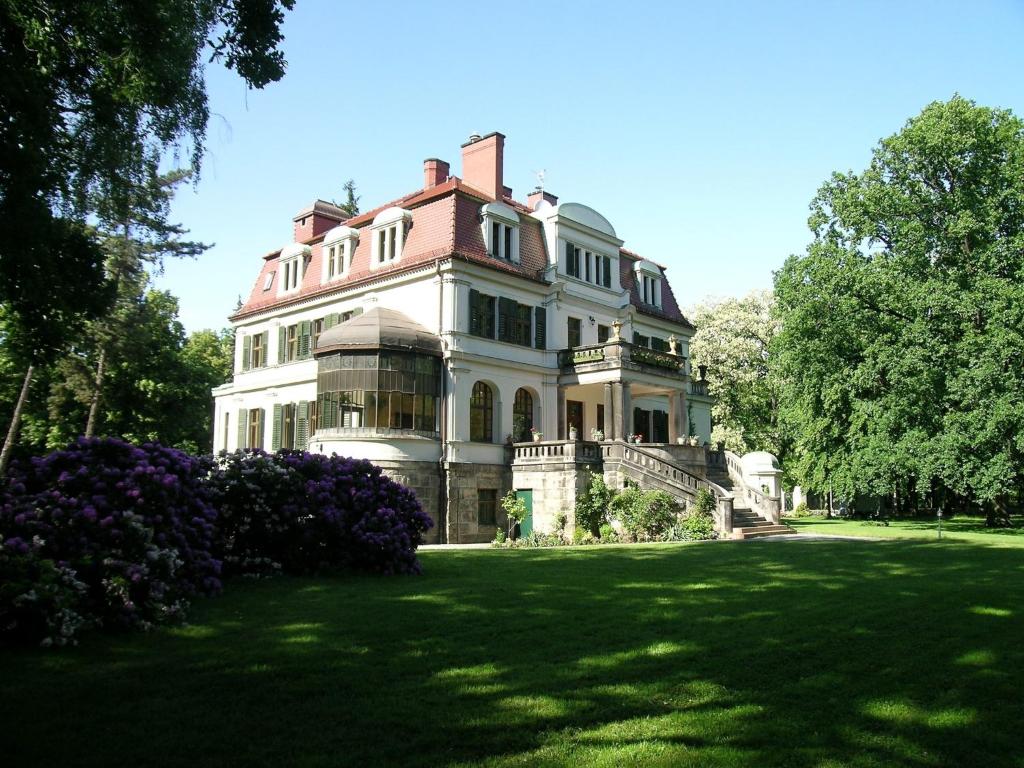 a large house on a grassy yard with trees at Rezydencja Janków in Iłowa