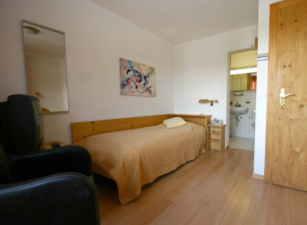 una camera da letto con un letto e un bagno di Hotel Pöstli a Maloja