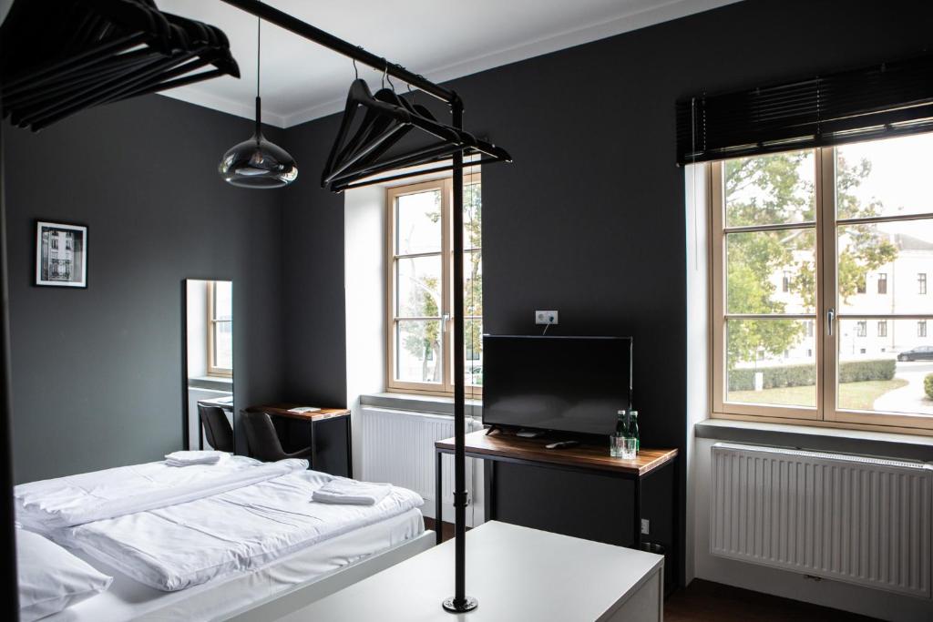 a black room with a bed and a television at Hotel Restaurant Joseph in Bruckneudorf