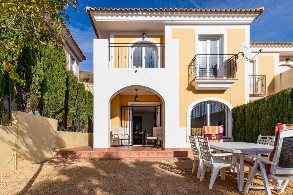 a house with a table and chairs in front of it at Casa la Rosaleda in Muchamiel