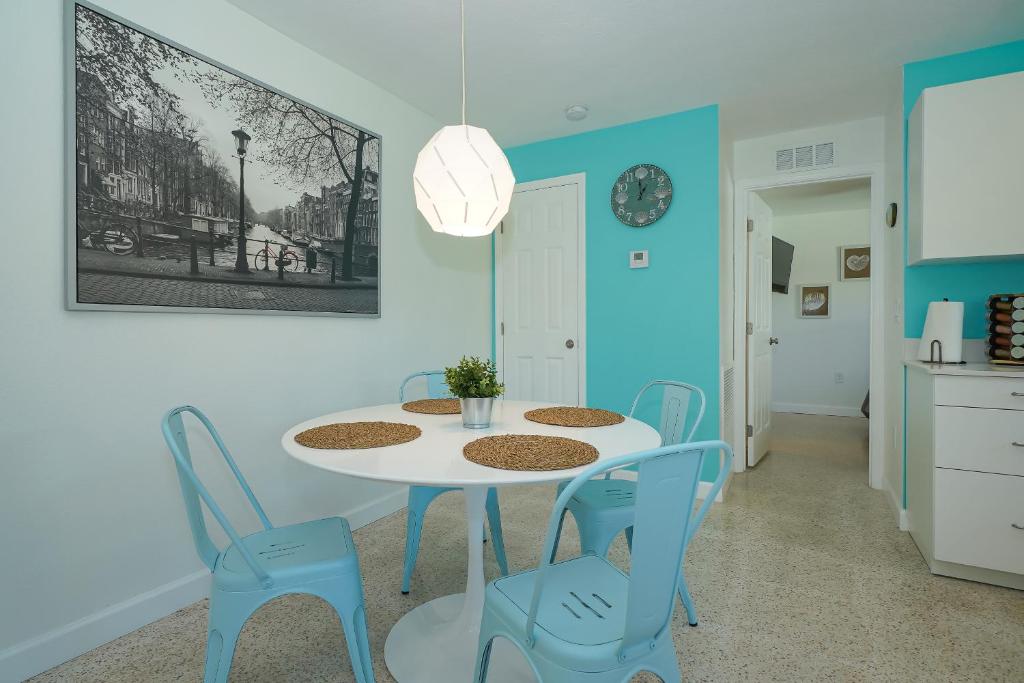 una sala da pranzo con tavolo bianco e sedie blu di Modern & Fresh - Less than 3 miles to the Beach! a Sarasota
