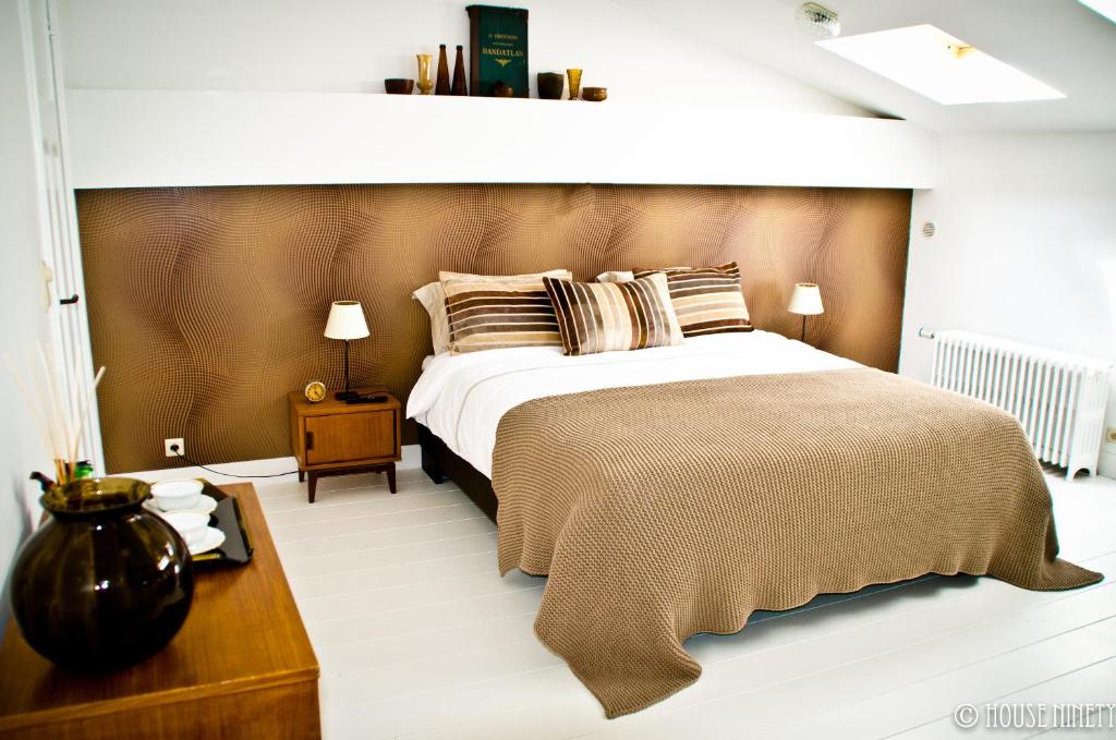 sypialnia z dużym łóżkiem i drewnianym zagłówkiem w obiekcie B&B House Ninety w Brukseli