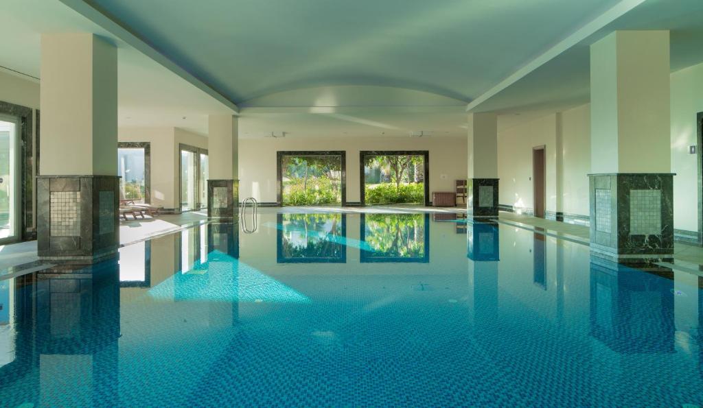 a large swimming pool with blue tiles in a building at Xanadu Island in Akyarlar