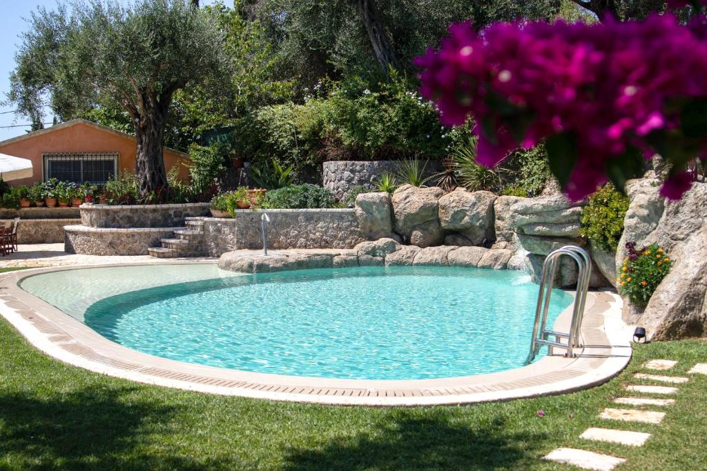 una piscina en un patio con flores púrpuras en The Red Bougainvillea Apartments en Corfú