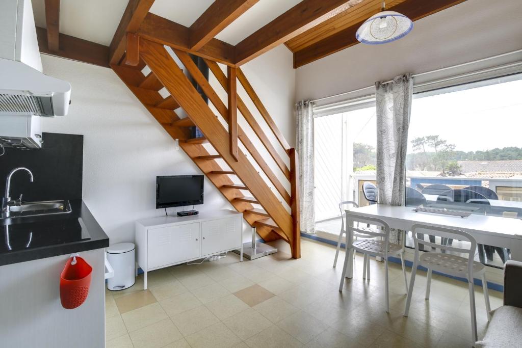una cucina e una sala da pranzo con tavolo e finestra di Appartement en duplex 2* Résidence Les Pêcheurs a Biscarrosse