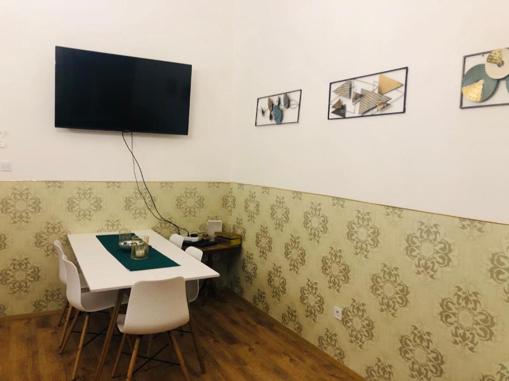 Pokój ze stołem i telewizorem na ścianie w obiekcie Modern Classic on Kiraly w Budapeszcie