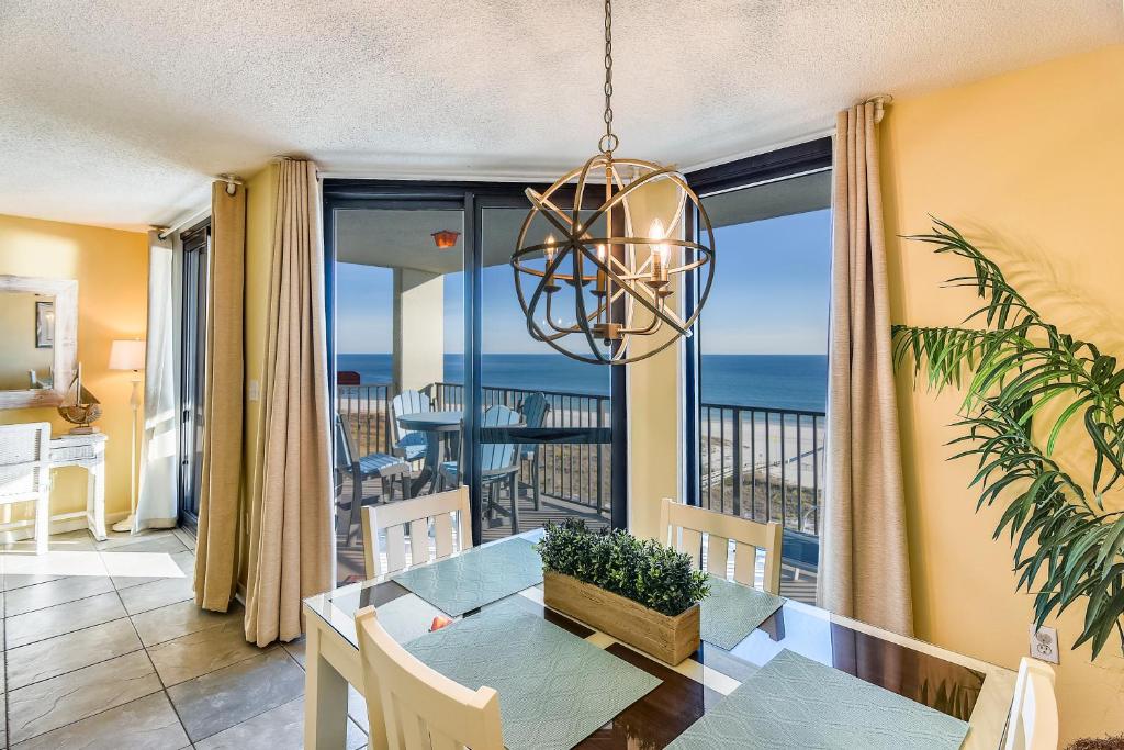 a dining room with a table and a view of the ocean at Phoenix 6 Unit 802 in Orange Beach