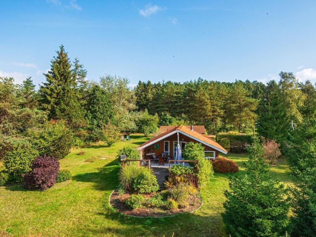 een klein huis midden in een tuin bij Holiday Home Lærkevej VI in Ebeltoft