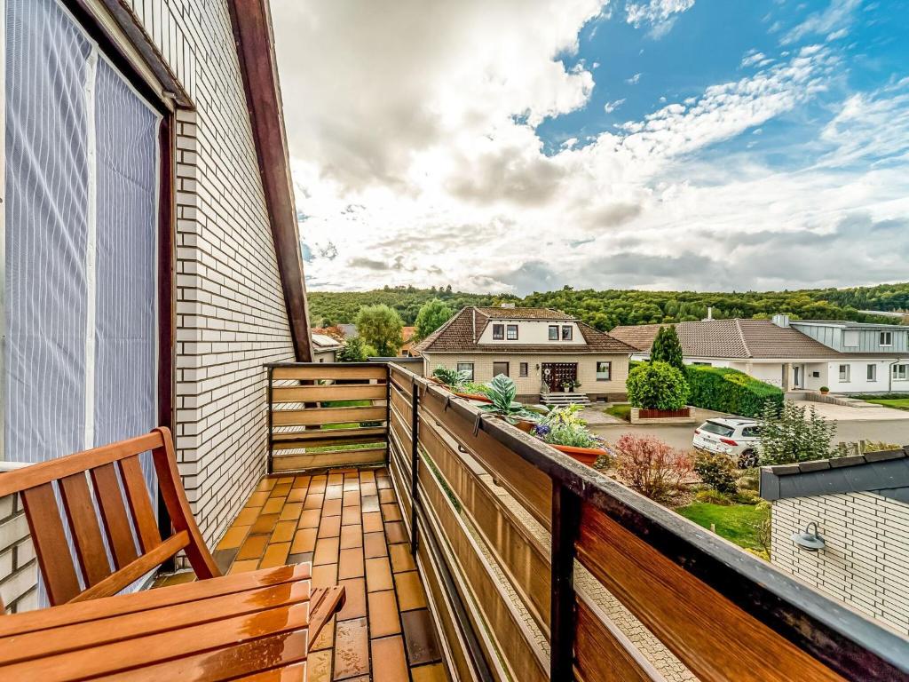 een balkon met een bank en uitzicht op een tuin bij Cozy Apartment in P hlde With Sauna in Herzberg am Harz