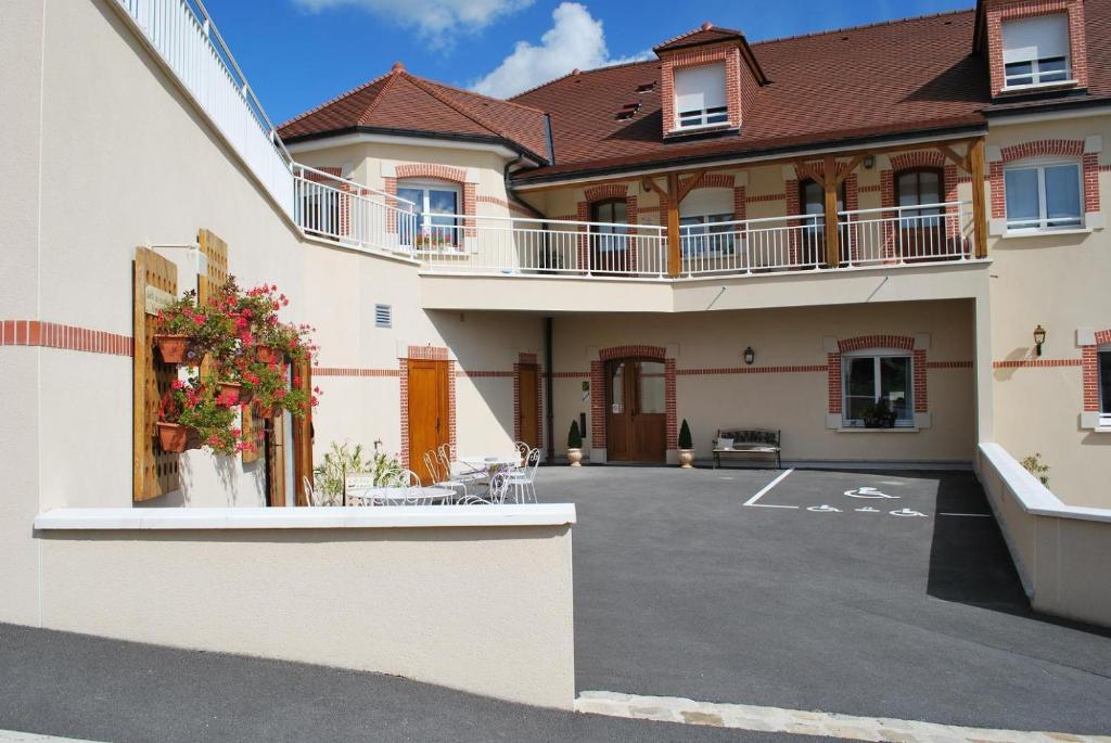 a large building with a parking lot in front of it at Pré en Bulles in Trépail
