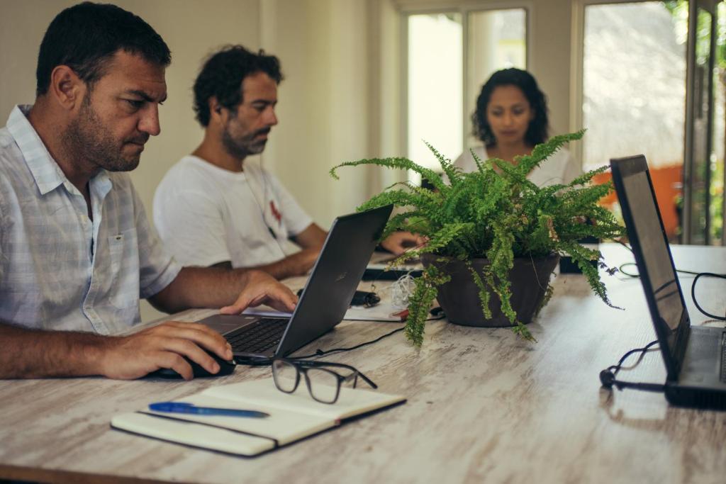 a group of people sitting at a table with a laptop at Casa Losodeli & Coworking- Adults Only in Puerto Escondido
