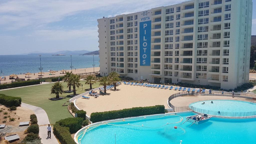 un grand hôtel avec une grande piscine et une plage dans l'établissement Departamento Papudo Laguna 120, à Papudo
