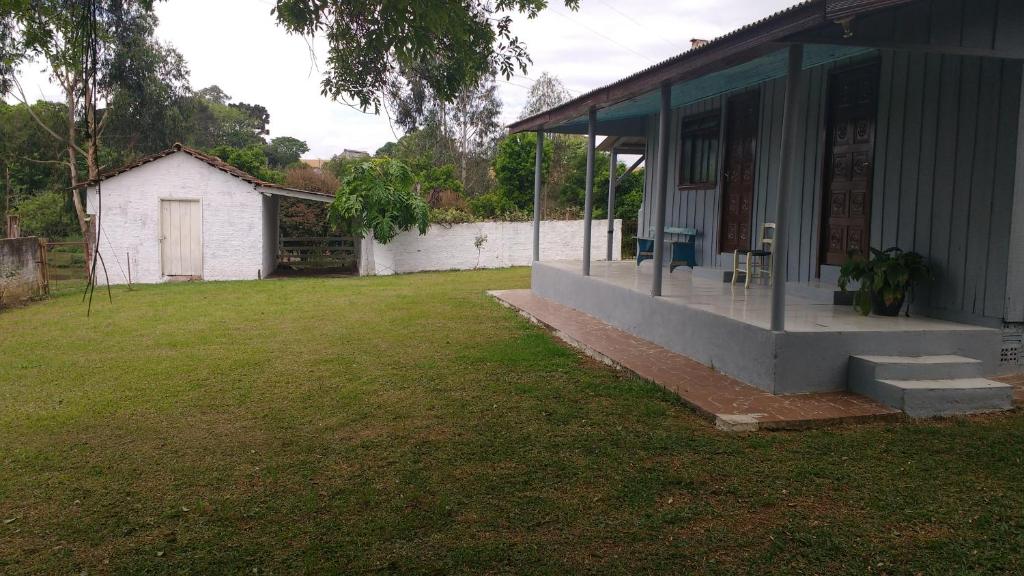 uma casa com um jardim de relva ao lado de um edifício em Casa chácara em Cará-Cará