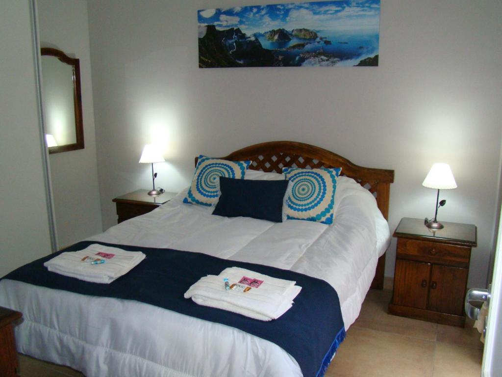 una camera da letto con un grande letto con asciugamani di Mis Nietos a Barraquero
