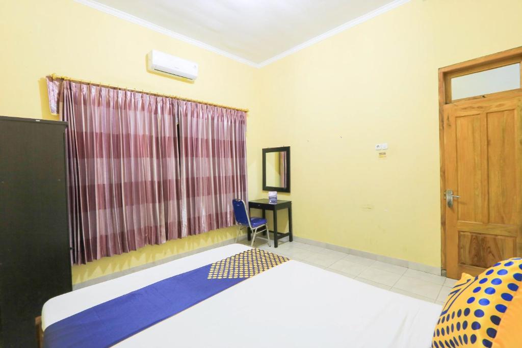 Postel nebo postele na pokoji v ubytování OYO 2440 Wallet Family Residence Syariah