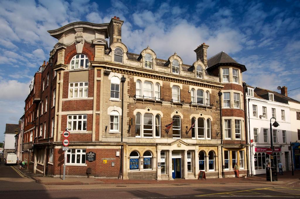 a large brick building on the corner of a street at The Crown Hotel in Weymouth