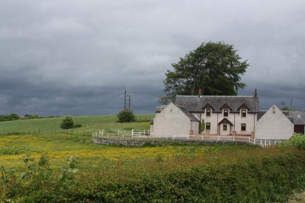 Ein altes Haus mitten auf einem Feld in der Unterkunft The Barn Lodge in Stirling