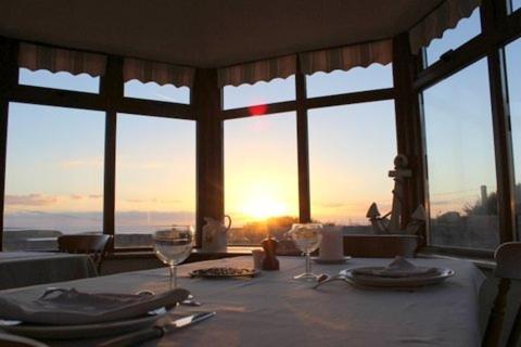 una mesa con vistas a la puesta de sol a través de una ventana en Clifden Bay Lodge, en Clifden