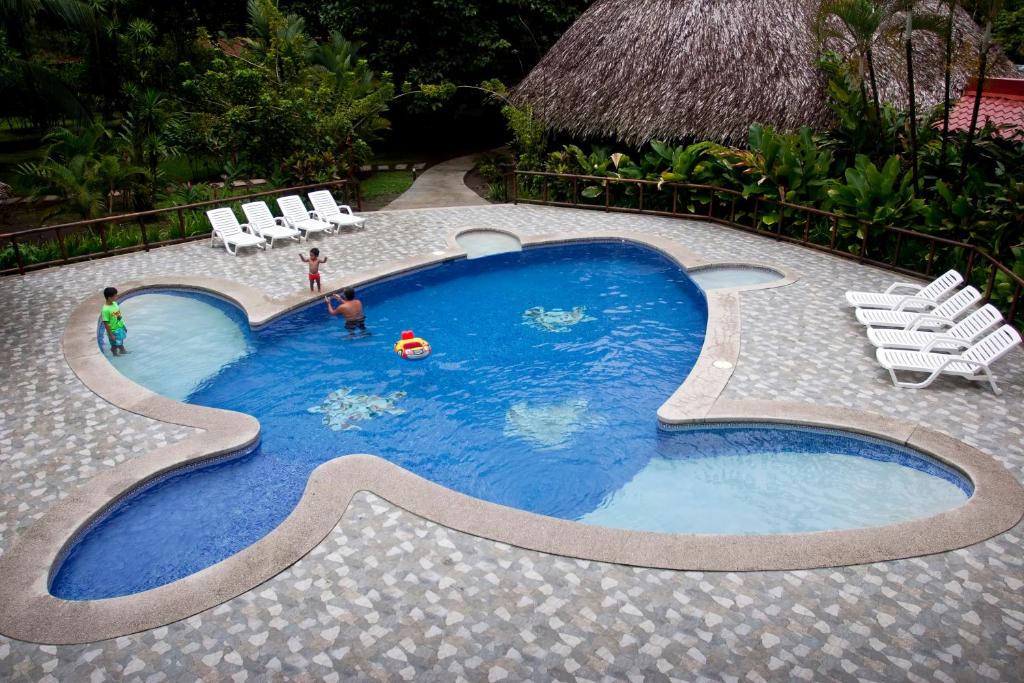 a small swimming pool with two people in it at Turtle Beach Lodge in Tortuguero