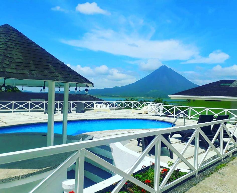 a swimming pool with a mountain in the background at Hotel Arenal Vista Lodge in Fortuna