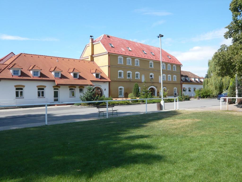 duży budynek z czerwonymi dachami na ulicy w obiekcie Hotel Na Statku w mieście Nepřevázka