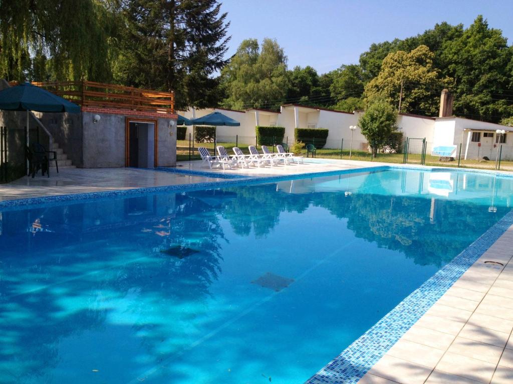 una piscina con sillas y agua azul en Motel des Bruyères en Lamotte-Beuvron