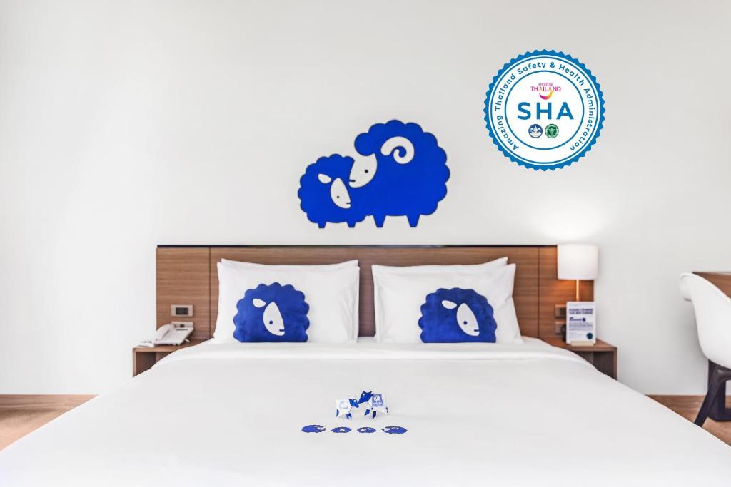 a bedroom with a bed with blue sheep decals at Kokotel Chiang Mai Nimman in Chiang Mai