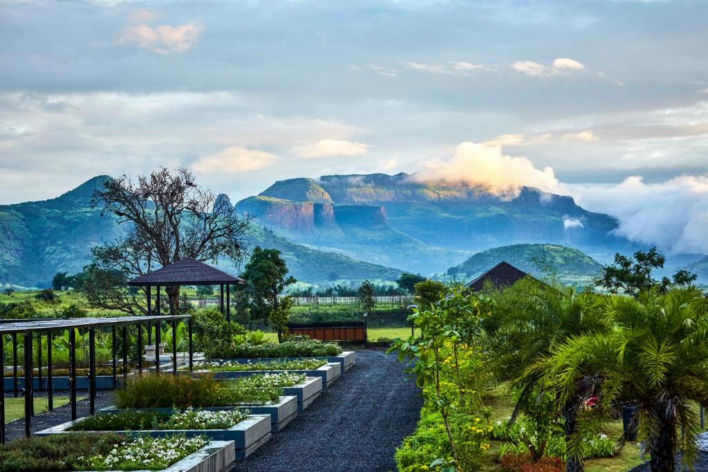 a garden with a view of a mountain at Viveda Wellness Resort in Nashik