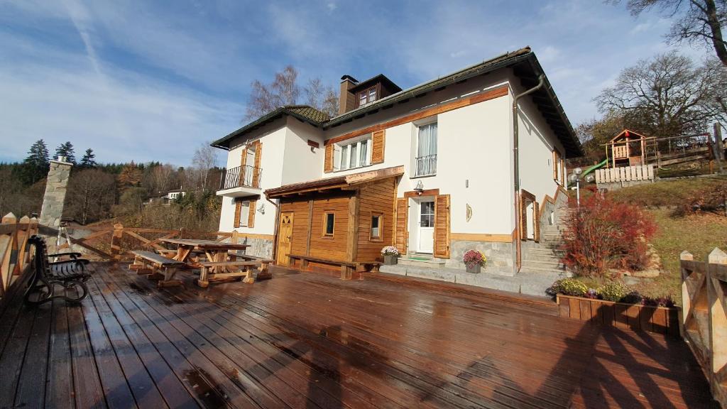 uma casa com um deque de madeira com uma mesa em Magic House Under Arber em Bayerisch Eisenstein