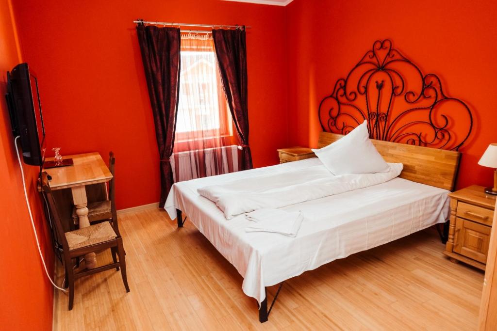 um quarto vermelho com uma cama e uma janela em Hotel President Cugir em Cugir