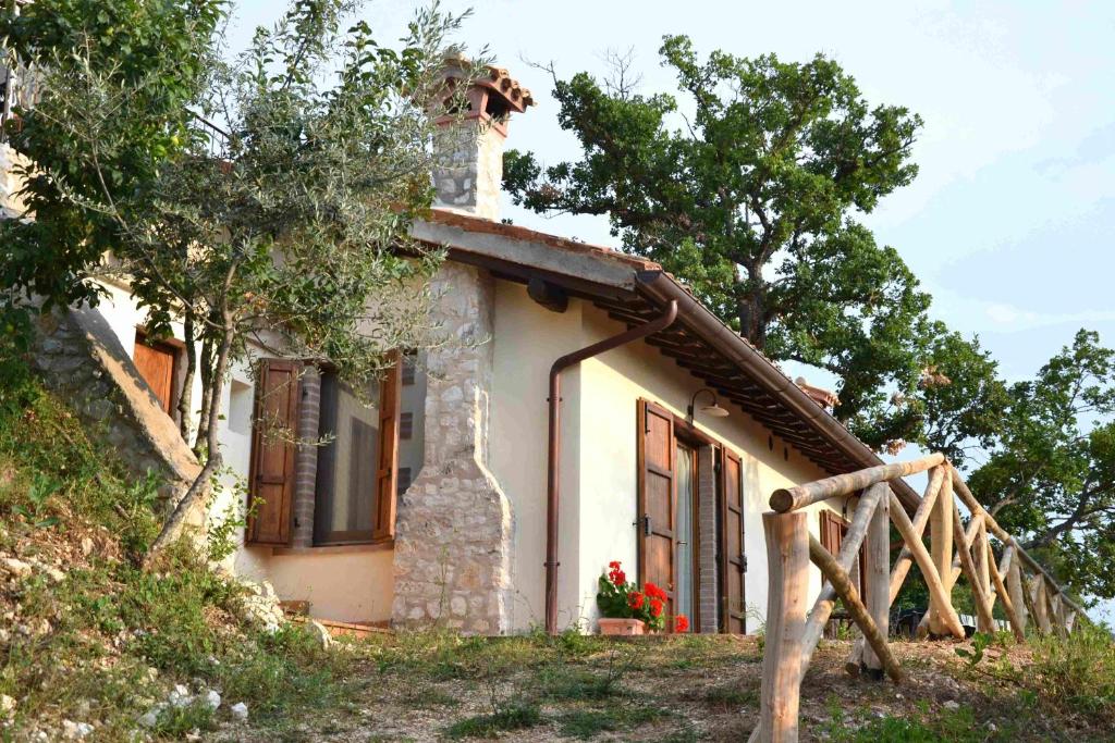 una pequeña casa con chimenea en una colina en Agriturismo Istrice Innamorato, en Campello sul Clitunno