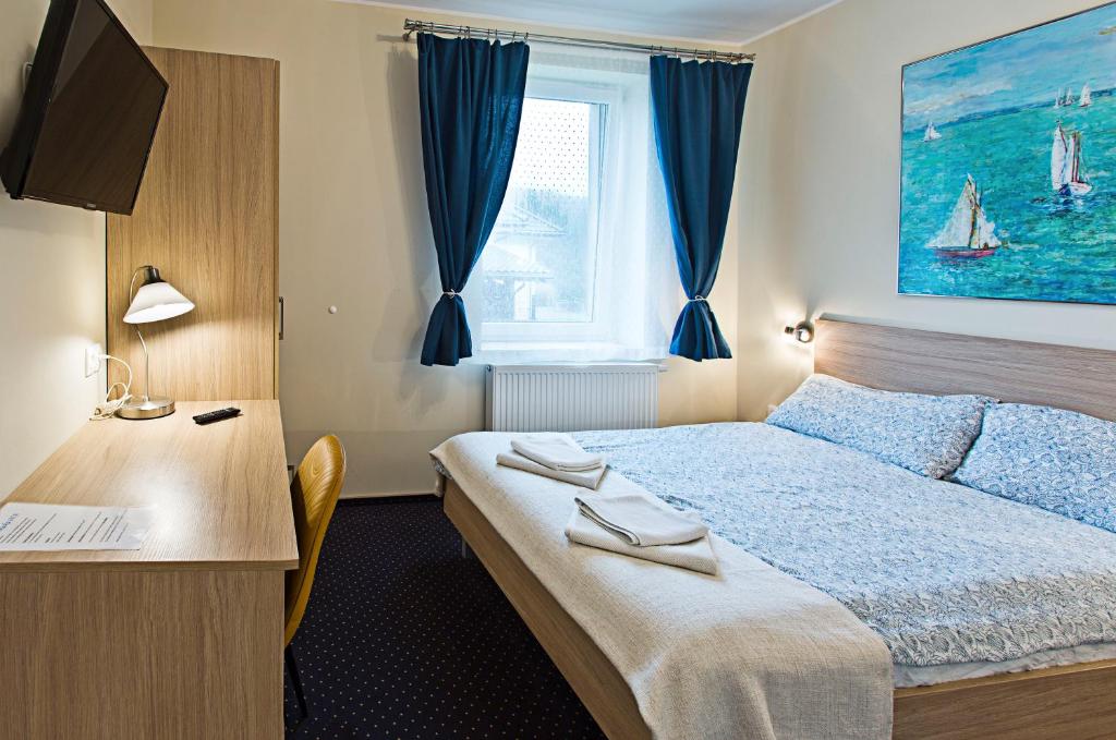 グディニャにあるOlkuska 107 Aのベッド、デスク、窓が備わるホテルルームです。