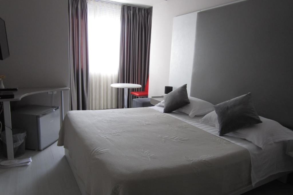 a hotel room with a bed and a television at Freddy's Hotel in Tirana