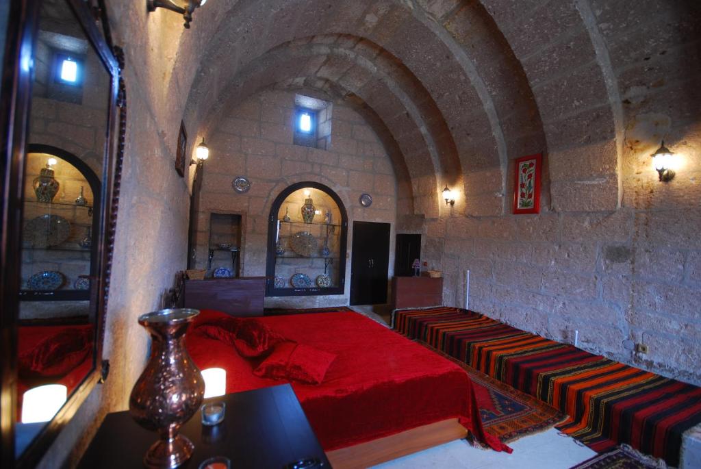 a bedroom with a red bed in a stone wall at Karamanli Konagi in Guzelyurt