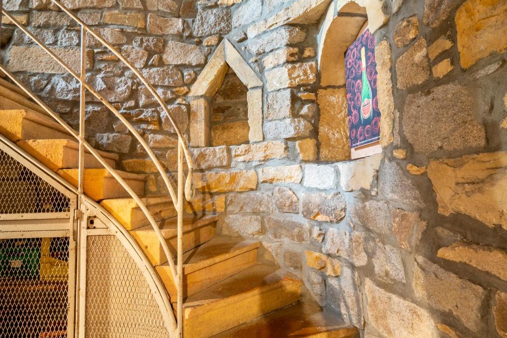 un escalier dans un bâtiment en pierre avec un mur en pierre dans l'établissement Aux Prisons de Montagny, à Montagny